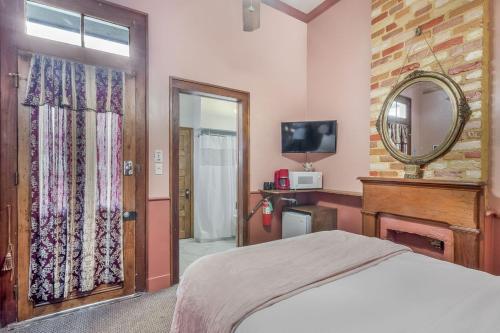 a bedroom with a bed and a mirror and a television at Royal Barracks Guest House in New Orleans