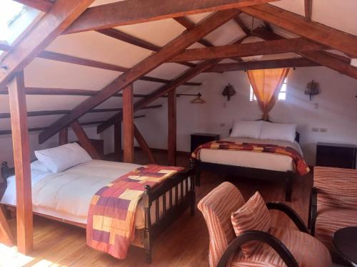 Dos camas en una habitación con vigas de madera. en Departamentos Cusco, en Cusco