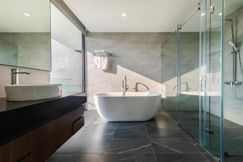a bathroom with a large white tub and a sink at Grand Villa Sân Golf - Venuestay in Vĩnh Phúc