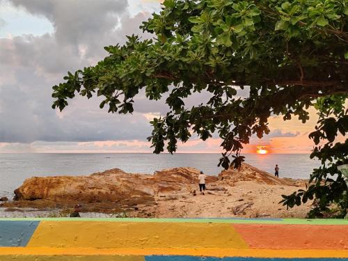 a group of people standing on a beach near the ocean at Sunset Seaview Bay Villa in Putatan