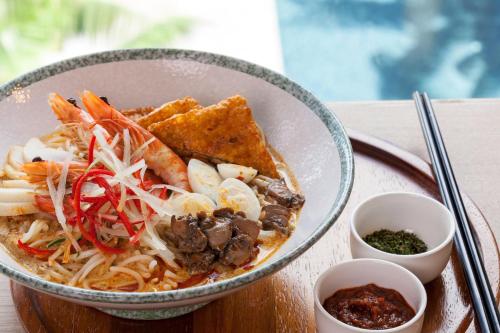 a bowl of food with noodles and other foods at Crowne Plaza Changi Airport by IHG in Singapore