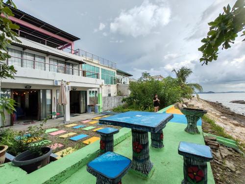 a picnic table and stools in front of a building at Sunset Seaview Bay Villa in Putatan