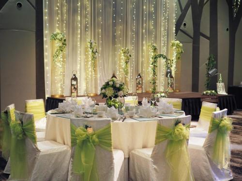 a dining room with white tables and chairs with green bows at Crowne Plaza Changi Airport by IHG in Singapore