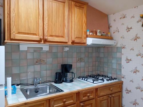 une cuisine avec un évier et une cuisinière dans l'établissement Maison de vacances à 500m de la plage avec piscine, jardin et équipements inclus - FR-1-639-126, à Saint-Gildas-de-Rhuys