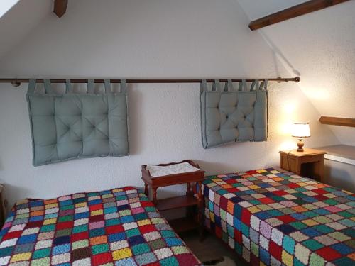 une chambre avec deux lits, une table et une lampe dans l'établissement Maison de vacances à 500m de la plage avec piscine, jardin et équipements inclus - FR-1-639-126, à Saint-Gildas-de-Rhuys