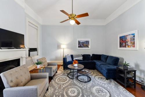 a living room with a blue couch and a ceiling fan at The Lanaux Mansion in New Orleans