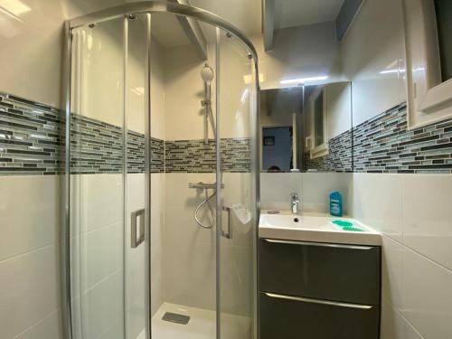 une salle de bain avec une douche en verre et un lavabo dans l'établissement Maison de vacances à 500m de la plage avec piscine, jardin et équipements inclus - FR-1-639-126, à Saint-Gildas-de-Rhuys