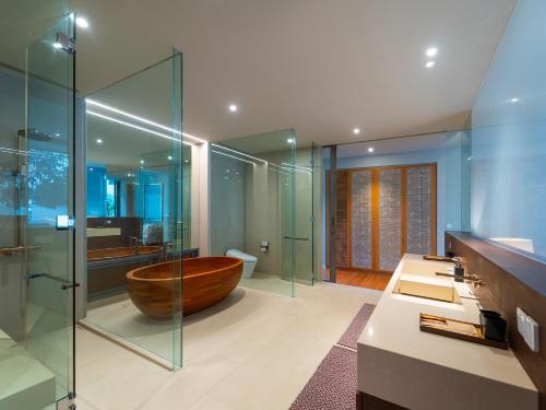 a bathroom with a wooden tub and a glass shower at Veyla Natai Residences - Luxury Pool Villa in Khok Kloi