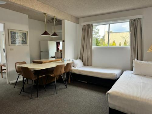 a hotel room with two beds and a table and chairs at Katoomba Town Centre Motel in Katoomba