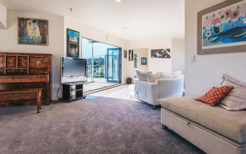 a living room with a couch and a television at Casa on Tawa, Oneroa - Be My Guest Waiheke in Oneroa