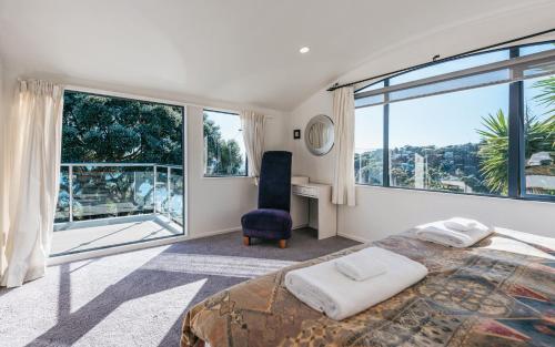 a bedroom with a bed and a large window at Casa on Tawa, Oneroa - Be My Guest Waiheke in Oneroa