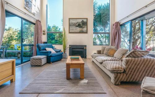 a living room with a couch and a table at Casa on Tawa, Oneroa - Be My Guest Waiheke in Oneroa