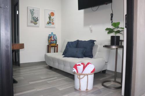 a living room with a white couch and a basket at Las 3 Carabelas BCS in El Sargento