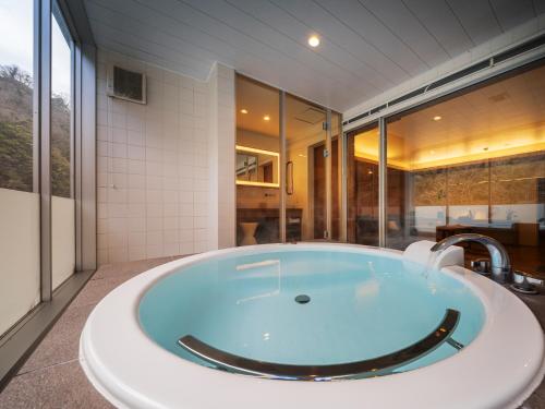 a large bath tub in a bathroom with a sink at Hakkei in Maniwa