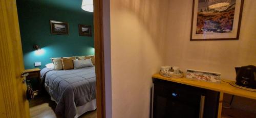 a bedroom with a bed and a green wall at Hospedaje Mi Rincón El Chaltén in El Chalten