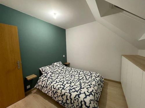 a bedroom with a bed with a black and white comforter at Maison indépendante avec jardin in Orvault