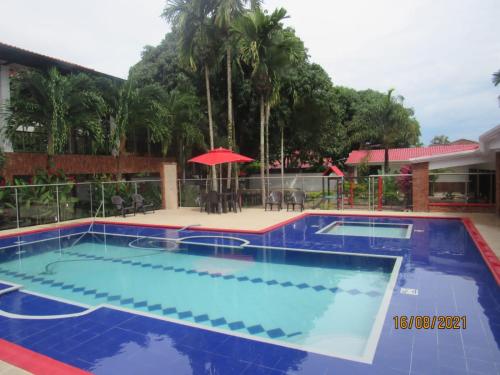 a pool at a resort with an umbrella at Quinta de san pedro in Villavicencio