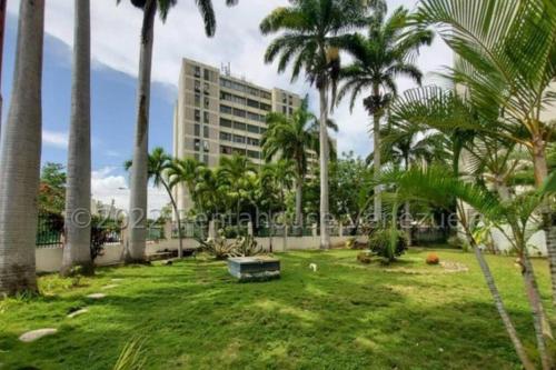 a park with palm trees and a tall building at Hermoso, Apartamento zona Este in Barquisimeto