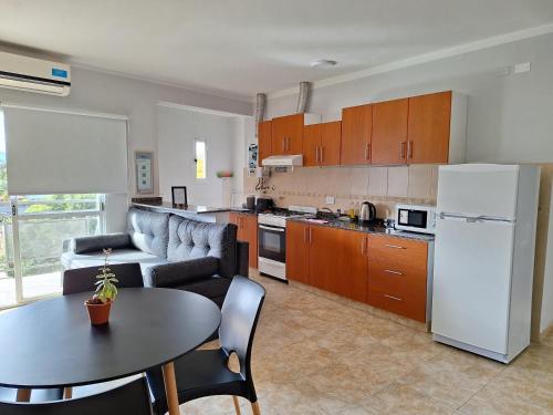 a kitchen and living room with a couch and a table at Departamentos Güemes in San Fernando del Valle de Catamarca