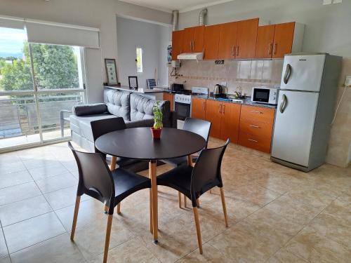a kitchen with a table and chairs and a refrigerator at Departamentos Güemes in San Fernando del Valle de Catamarca