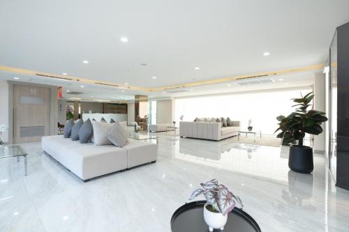 Ban Khlong ThewaにあるOriole Residence - Suvarnabhumi Airportの白いロビー(ソファ、テーブル付)