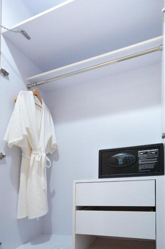 a closet with a white cabinet and a microwave at Oriole Residence - Suvarnabhumi Airport in Ban Khlong Thewa