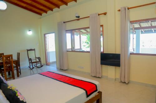a bedroom with two beds in a room with windows at Athithi Villa in Hikkaduwa