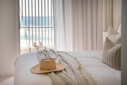 a hat sitting on top of a bed with a window at Little Groyne Kirra Beach Unit 602 in Gold Coast