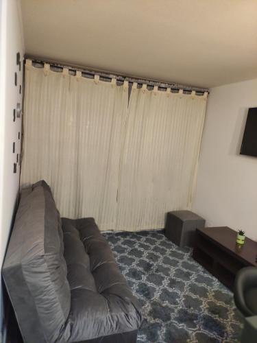 a living room with a leather couch in front of a window at 2108 Depto a 15 minutos del Aeropuerto frente mall in Santiago