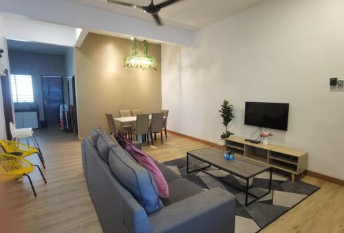 a living room with a couch and a table at Cosy 2-Storey Holiday Home Vines 2 @Pasar Malam -2 in Tanah Rata