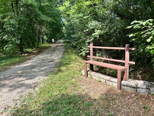 a wooden bench sitting on the side of a dirt road at Guest House Italo & Anna in Pasian di Prato