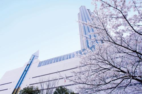 a building with pinkakura trees in front of it at ANA Crowne Plaza Kobe by IHG in Kobe