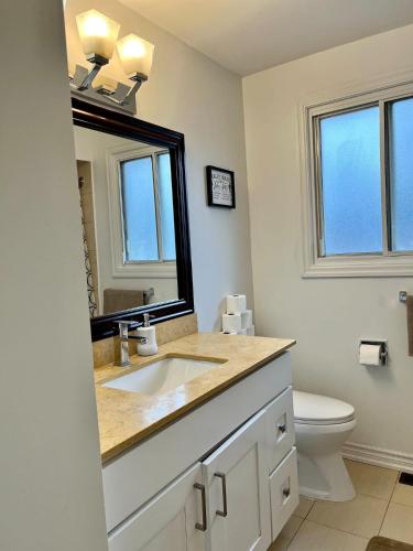 a bathroom with a sink and a mirror and a toilet at Key-04 Room Near Airport in Mississauga
