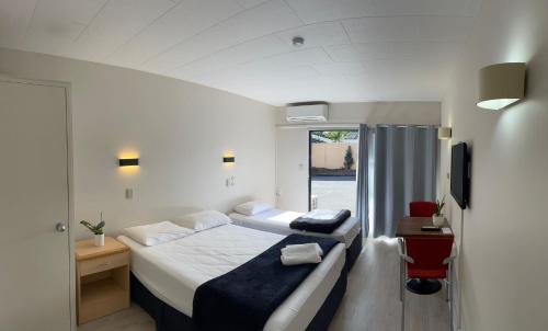a hotel room with two beds and a window at Rayland Epsom Motel in Auckland