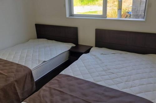 two beds sitting next to each other in a bedroom at メゾテラス宮古島 in Miyako Island