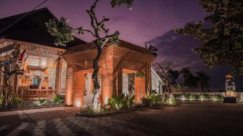 a brick house with a pavilion at night at Lovina Haven Boutique Resort in Lovina
