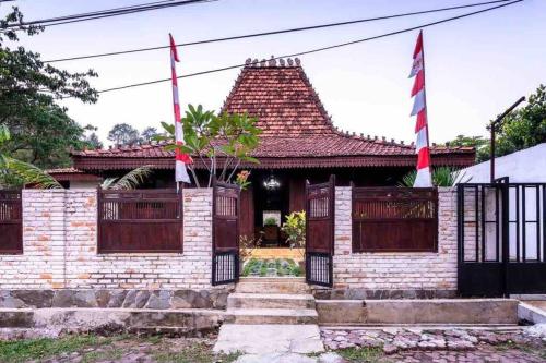 a brick house with two flags in front of it at Joglo House in Central Bogor By penggemarlawas in Bogor