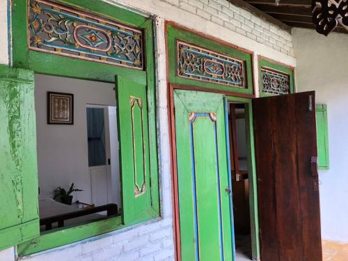 a green door and a mirror in a room at Joglo House in Central Bogor By penggemarlawas in Bogor