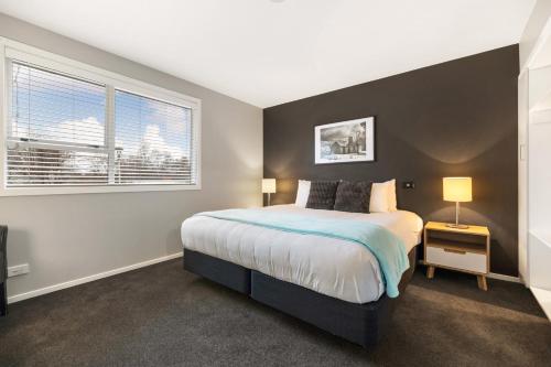 a bedroom with a large bed and a window at Arrowtown Motel in Arrowtown