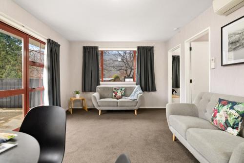 a living room with two couches and a window at Arrowtown Motel in Arrowtown