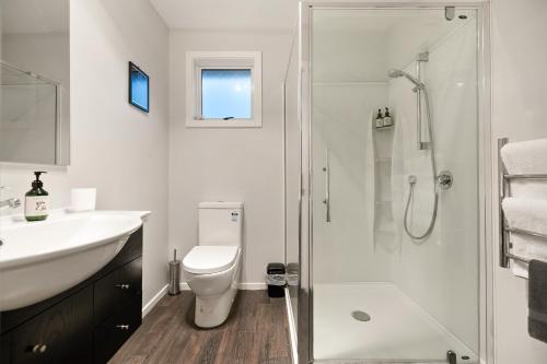a bathroom with a shower and a toilet and a sink at Arrowtown Motel in Arrowtown