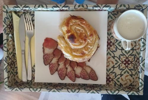 a plate of food with a pastry and bacon at Chechar Inn Zlatar in Nova Varoš