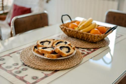 a table with bread and a basket of fruit at Grand Cozy Apt Close to the Beach in Struga