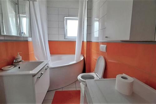a bathroom with a tub and a toilet and a sink at Grand Cozy Apt Close to the Beach in Struga
