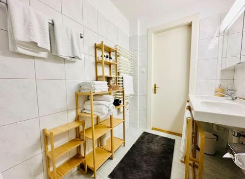 a bathroom with a sink and a shelf with towels at Villa Sunshine - Lake Zurich Gold-Coast in Zollikon