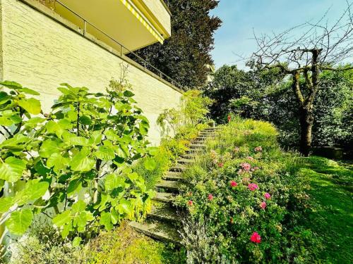 a garden with stairs and flowers next to a building at Villa Sunshine - Lake Zurich Gold-Coast in Zollikon