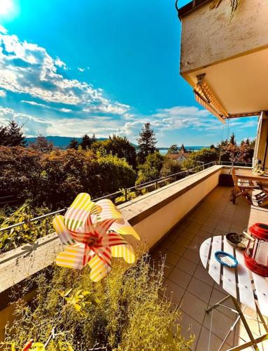 a balcony with a table and an umbrella on it at Villa Sunshine - Lake Zurich Gold-Coast in Zollikon