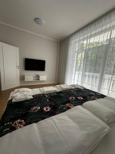 a bedroom with a large bed with a flower blanket at Apartmán Beethoven in Turčianske Teplice