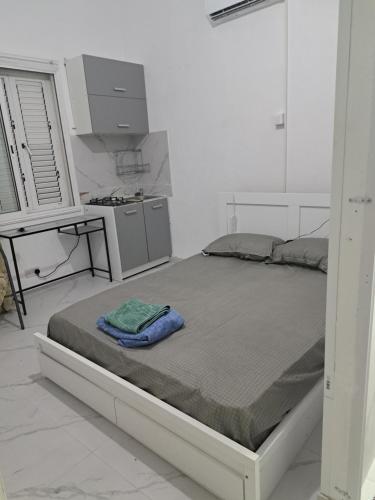 a large bed in a white room with a kitchen at Limassol Center Studios in Limassol