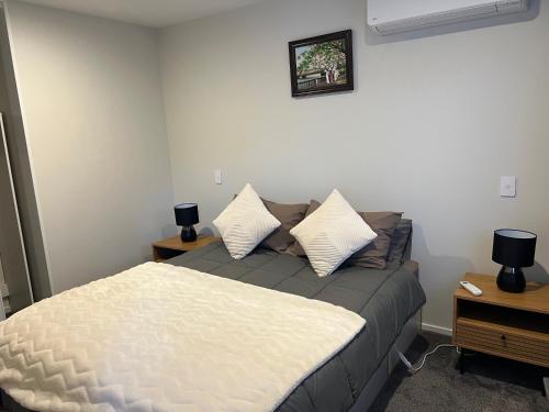 a bedroom with a bed and two night stands at Christchurch Airport Stop in Christchurch